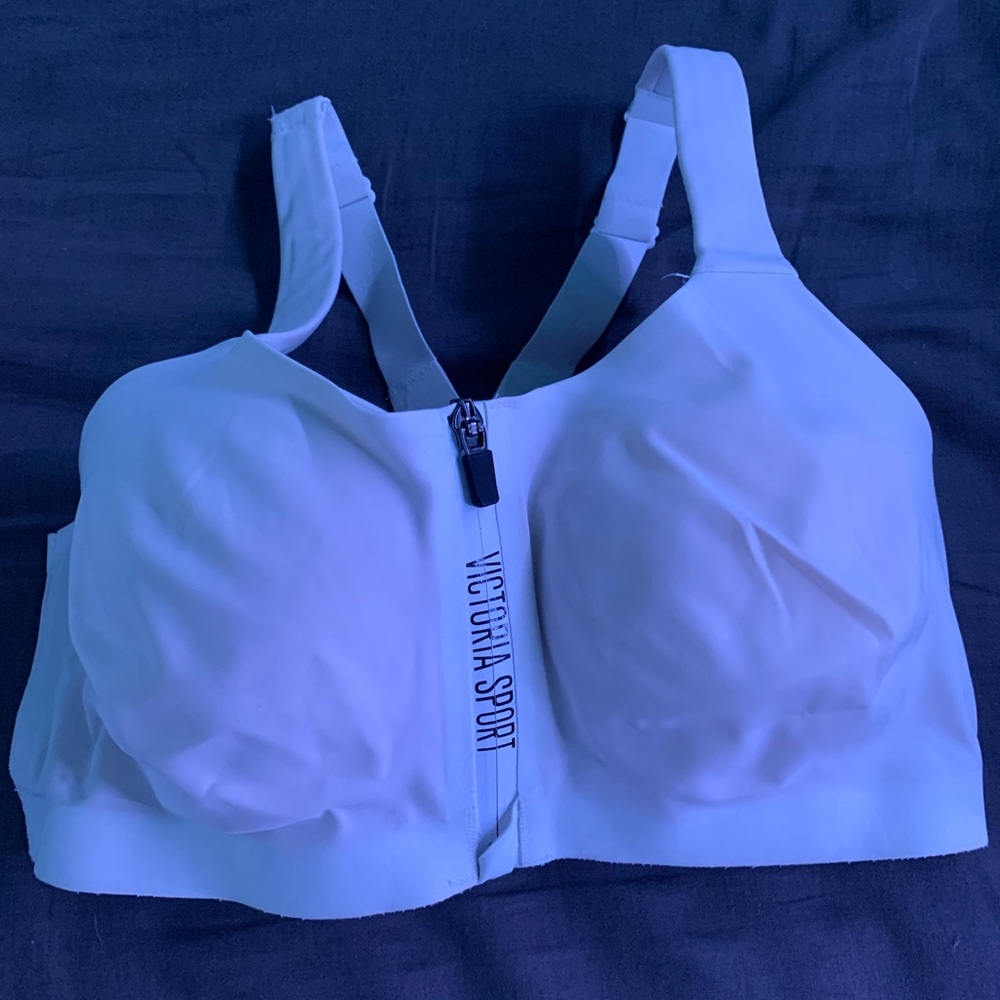It is a white sports bra with a zipper and  clasps